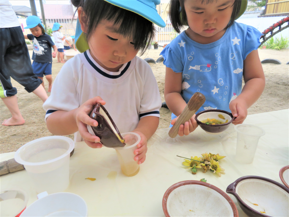 水遊び・・・　　砂遊び・・・
子どもたちは遊びの中で大人がうらやましくなるほど、想像を膨らませています。



「うわぁ～　きれいな黄色！」
「ジュースができた」
ちょっとずつ・・・　ちょっとずつ・・・
お花で作った色水を大切にしています。