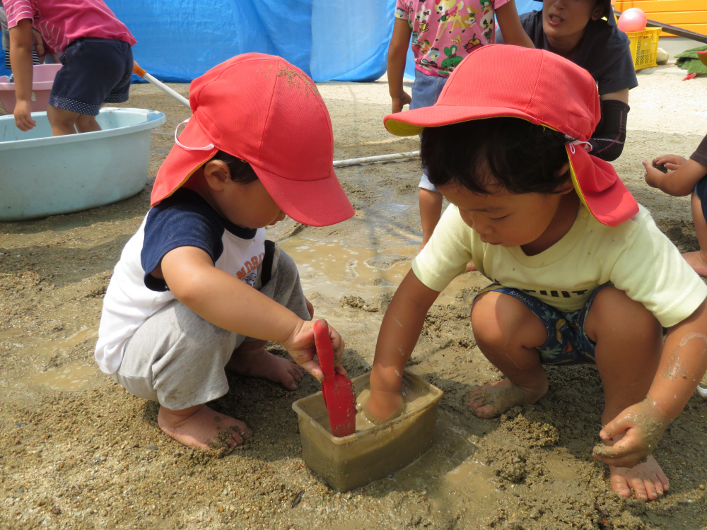 先生が一生懸命作ってみても、きっと子どもたちが作ったグニョグニョはつくれません
どうしてグニョグニョになるんだろう？



「　・・・。　」
砂を入れて混ぜて・・・　水を入れて混ぜて・・・
手を入れて・・・　確認して・・・

“きもちいい”
その感覚は子どもたちが遊びながら作っていきます
先生が触っても、やっぱりきもちいい！！