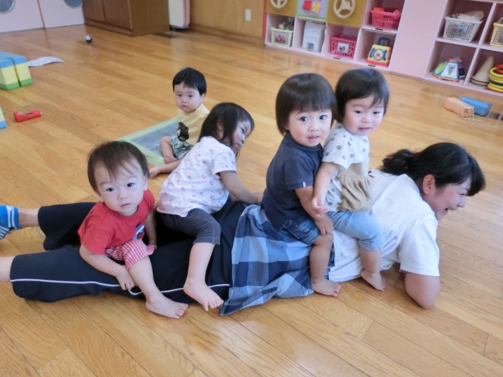 子ども達の人間関係は、先生との関わりから、徐々にお友だちへの興味がではじめ、子ども同士の関わりへとうつりかわっていきます。

0歳児さんでは、先生としっかりと信頼関係を築きび、安心して身を任せ、
「先生といっしょにあそびたい！」
「先生ににくっつきたい！」
という姿がたくさん見られています。

そんな一コマです。