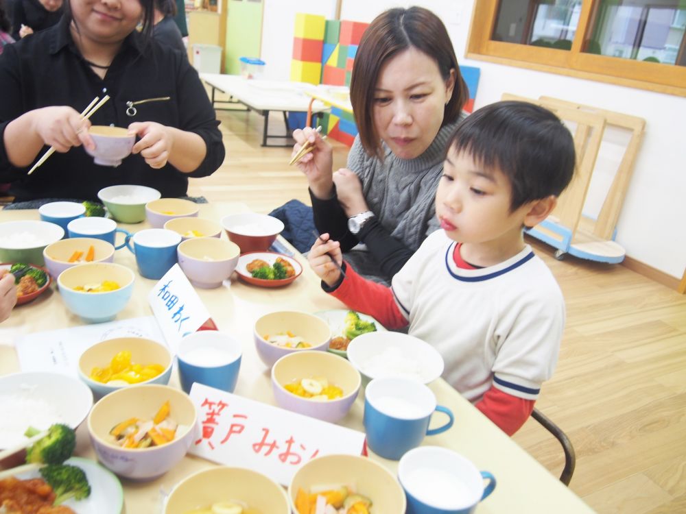 今回の保育参加では、子ども達が普段食べている給食をゾウ組の保護者の方に試食してもらいました！
メニューは子ども達が決め、園でも大人気の「鶏の甘辛あげ」になりました。

ゾウ組さんは、月間絵本をきっかけに、とても調味料に興味を持っています！
普段の給食の時間にも、今日の給食には何の調味料が入っているかクイズをしたり、メニューによっては使われている調味料が一緒でも、味が全然違うね！と様々な発見をしてくれます。

また、秋頃から箸を使うようになりました。
初めは手に力が入り過ぎていたり、慣れない様子もありましたが、最近では徐々に上手に使えている姿が増えました！
