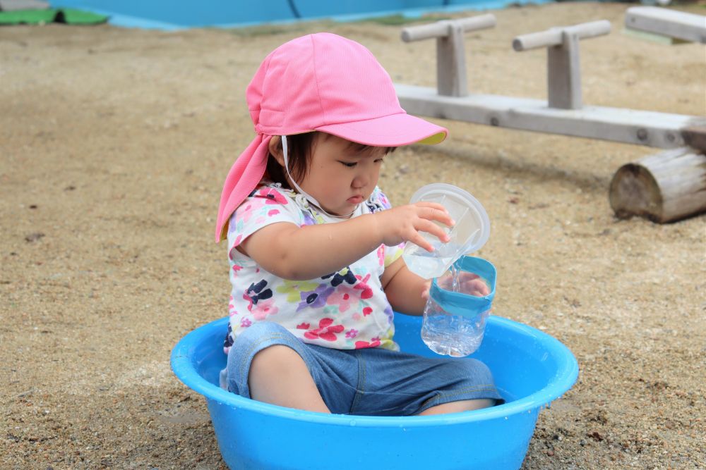 外では・・・

水を汲んでは・・　入れ物に流すMちゃん…
静かに繰り返し　何度でも・・　何度でも・・

見つめる先には細く流れる水
右手の傾き加減で流れる量が変化したり・・　早くいっぱいになったり・・

真剣な表情でいろいろ試していますね