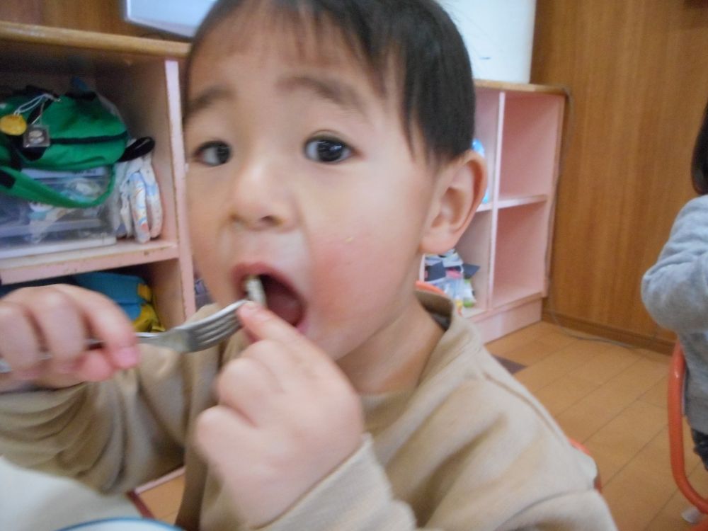 《2歳児》
上手にれんこんだけ残しているE君。お皿にはたくさんのれんこんだけ・・・。
どうするかな？と見ていると、決意したようにフォークを構えました。
でも、そこからお皿までいけず、手が止まっています。
悩んでいるんだろうなぁ・・・すくう勇気がでないのかなぁ・・・。
「これねぇ、先生が切ったんよ～。シャキシャキって音がしたよ。」
と給食先生が伝えると・・・
「見ててね」というように、先生をじっと見て、大きな口を開け、れんこんを口の中へ！　苦手なものへの挑戦☆大きな第一歩ですね♡
食べてみると好きな味だったのか、その後パクパクパクっと食べて、完食してくれました♡