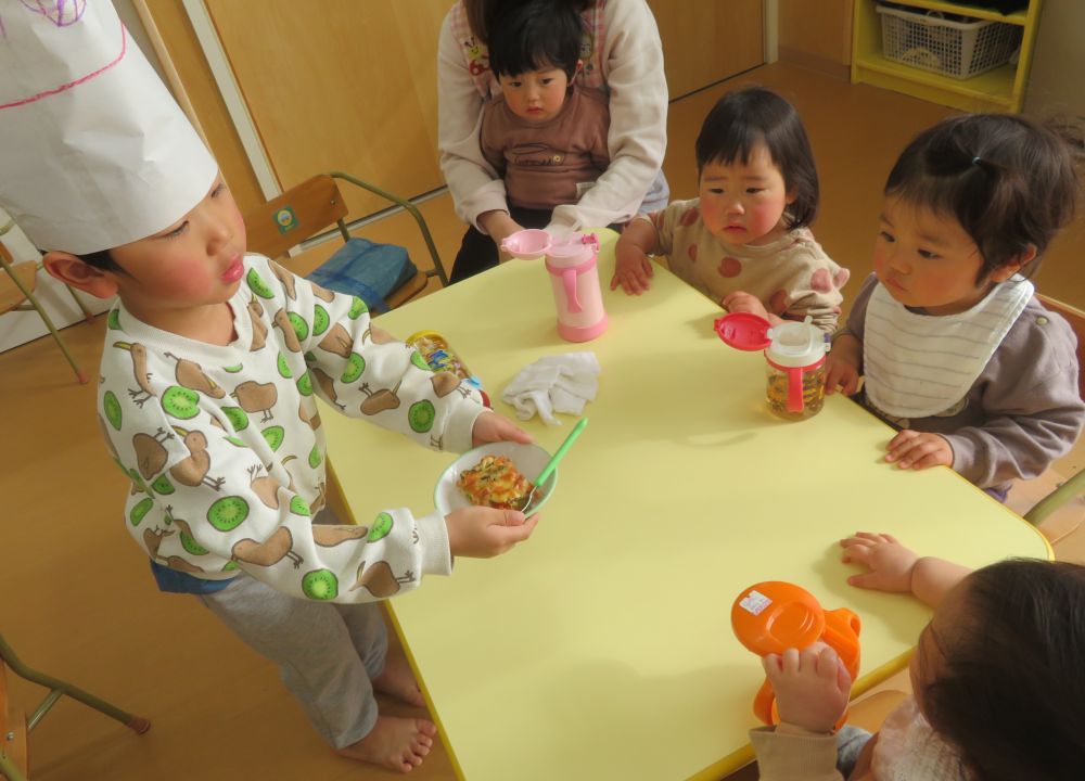 焼き上がると、良い匂いがしてきます♪
作ったライスピザを二人がお友達に配ってくれました。
「コックさーん！こっちにお願いしまーす！」

今日のおやつはリス組さんが作ってくれてとってもおいしかったです♡
「リス組さん、おいしいよ～！」「作ってくれてありがとう！」と伝えている姿はとても微笑ましかったですよ♡
クッキングを通して、楽しくおいしく食材に触れることが出来ました☆
