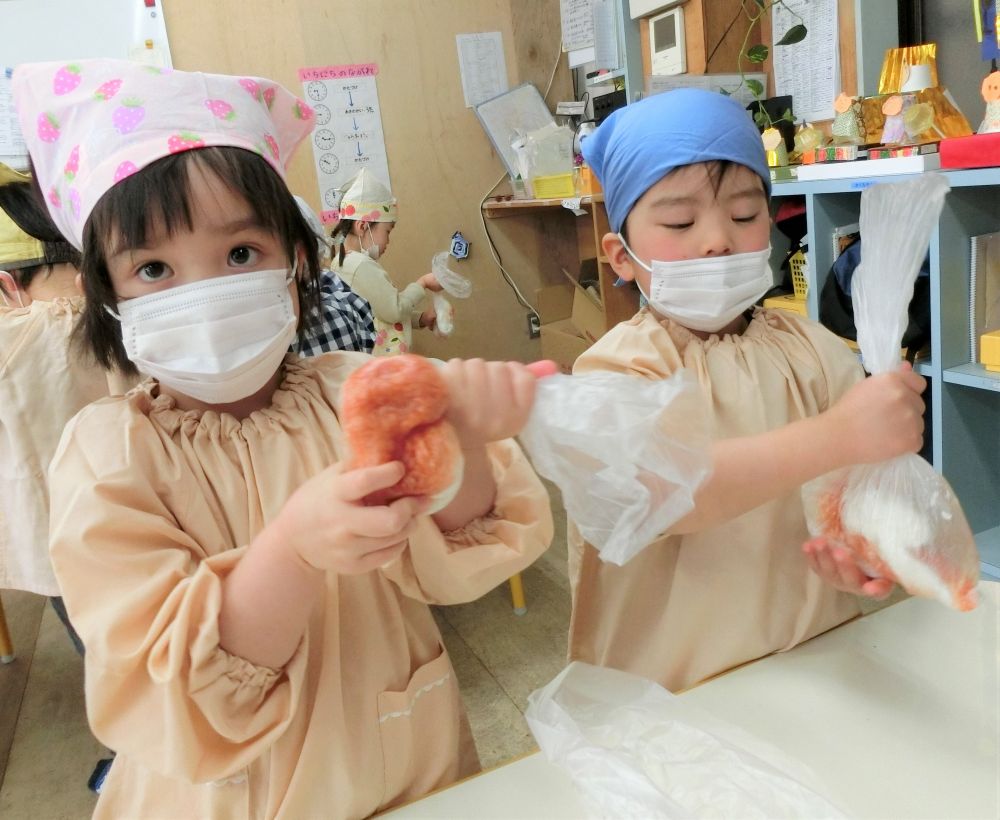 リス組さん、今年度最後のクッキングは朝からソワソワなんだか落ち着かない様子。
楽しみでワクワクしている様子が伝わってきます❤

今日は冬野菜を使って【ライスピザ】に挑戦！！
冬の野菜ってどんなものがあるかな？
｢これは何の野菜かな？？｣と水菜を見せると・・・
｢？？？｣
ちょっと難しかったかな。笑
でも水菜であることを伝えると｢食べたことあるよ｣と言う声も返ってきました。
お鍋に入っていたり、お正月にお雑煮に入っていたかもしれませんね。
その後、マイタケ、エリンギ、白菜などなど材料の説明をしました。

さあ、いよいよみんなで作ろう！
ビニール袋にご飯を入れて少しのケチャップを入れてし、しっかり袋を持ってもみもみ・・・
