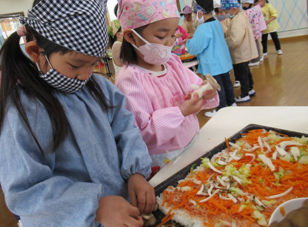 炊きたてご飯をモミモミしてつぶし、鉄板に敷きつめたら、今度はおいしい味付け！
ケチャップをスプーンにとり、塗っていきます。
「ぜーんぶのご飯に味がつけれるかな～？」と伝えたものの・・・ついつい最初が多くなってしまい・・・あれっ、最後まで足りるかな？？と見ているこちらは心配に（笑）
「あっ！ここ塗ってないのにケチャップもうない・・・」と色んなテーブルから聞こえてきます。
そんなときはどうする？
「多く塗ったとこから持ってこよう！」となり、みんなで手直し。なんとかピンチを切り抜けました♡

