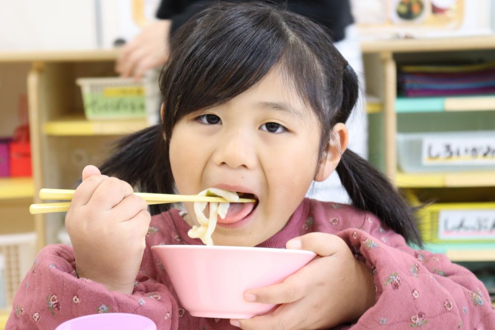 切り終わるとすぐに茹でて、温かいお出しをかけて出来上がり♡
「はぁ～いいにおい～」
「早く食べよ～」と待ちきれないキリン組さん。
出来たてをみんなでいただきます♪
「おいし～い！」
「もっちもちじゃね」
「この麺、太すぎじゃない？」
といろんな感想が飛び出します☆
「みんなでうどん屋になれるじゃん！」と言う子もいましたよ(笑）

園生活最後のクッキング、「わくわく」「楽しい」「難しい」「やりたい」「できた」「おいしい」と、いろんな気持ちが溢れる時間だったように思います。
家庭でもぜひ、お話を聞いてみて下さい♡