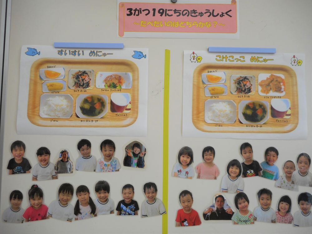 卒園式を間近に控えた、3月の食育の日。

子どもたちと何か楽しいことをしたい！との思いから、去年から実施している【お楽しみメニュー】。
主菜2種類の中から、“食べたい方を自分で選ぶ”という選択メニューです♪
いつもは決まった献立ですが、好きな方を選べる！というちょっとした喜びが、子どもたちをワクワクさせるようで・・・
一度選んで、自分の顔を貼っても「やっぱりこっち」となり、次の日には違う方に貼り替えていたり・・・「どっちにしよう」と選ぶ楽しさを味わっていました。