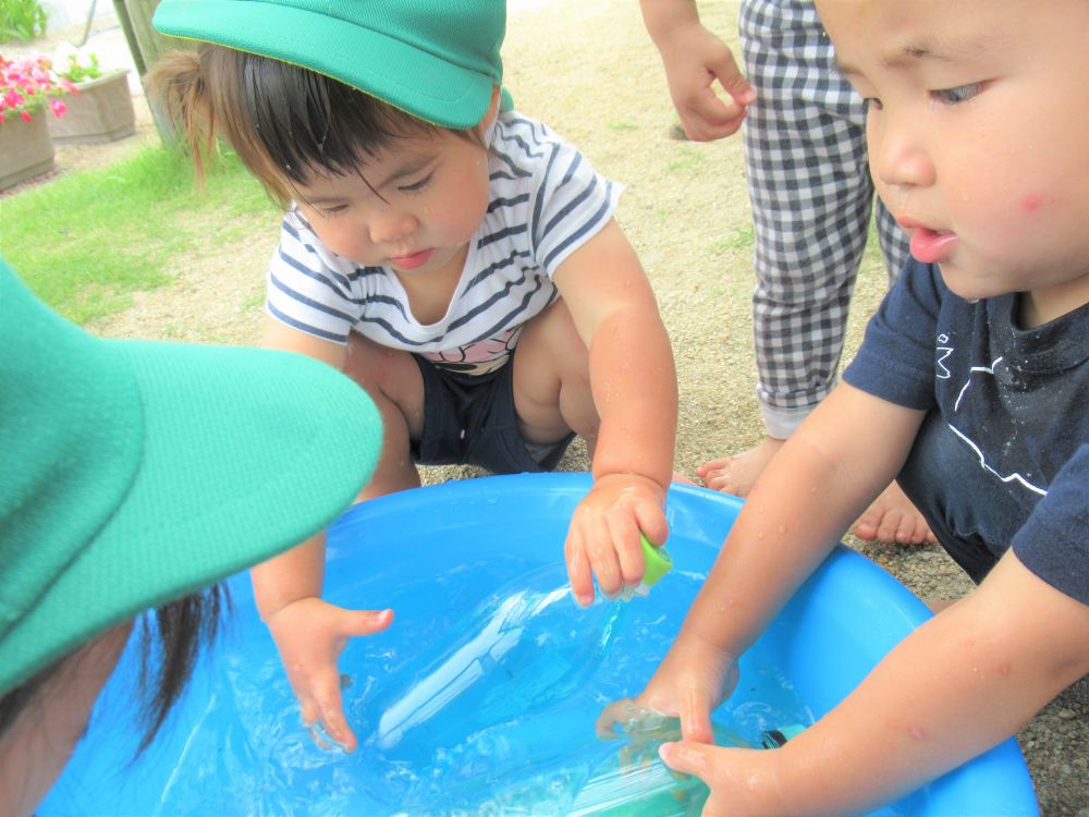 

すると今度は水が入った桶に入れて・・・

Uちゃん「なーい」「あれ～」
先生「あれ～ないね～」
見てみるとペットボトルが消えて見えました

Uちゃんが持っていたのは青色の水が入ったペットボトル…