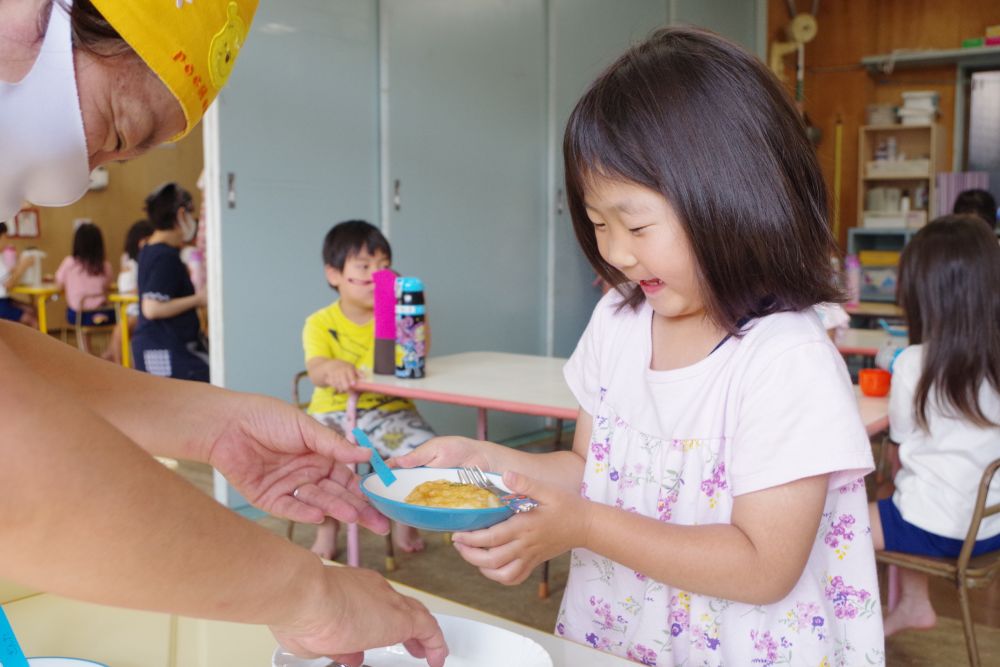 次は上新粉と塩を入れて、またまたコネコネ・・・
なかなかじゃがいもと上新粉が混ざらず悪戦苦闘する場面も見られましたが、
みんな綺麗な団子！？餅！？が出来ました♡

自分で作ったものが分かるようにしっかり付箋をして給食先生が仕上げをします。
その間に片付けをして手を洗ってワクワクしながら少し待ちます。
熱々で出来たてを｢○○ちゃん｣と先生が名前を呼んで自分で作ったおやつを受け取りました。
みんなとっても嬉しそう♡

ホクホクのいももちはあっという間に完食です。
普段あまり好きではないお友達も自分で作るとパクパク食べることが出来ました。
不思議ですね・・・♡クッキングはそんなすごい力を発揮するのだなっと改めて感じました。

簡単なのでご家庭でも作ってみてくださいね。
ごちそうさまでした。

