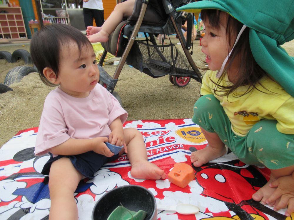 入園して少しずつ園の生活に慣れてきたIちゃん
始めは抱っこや私たちの膝で過ごすことが多かったけど、少しずつ離れて遊べるようになってきました

園庭ではシートに座って、スプーンを持ってお話をしてくれます♪
「あああ…（おいしいね～♡）！」って言ってるみたい

しばらくしたら、ヒヨコ組のNちゃんがやってきて「何してるの～？」と、Iちゃんに声をかけ顔を覗き込んでいました
NちゃんはIちゃんと目が合ってニッコリ♡
この後Nちゃんが、お椀にきれいなお花を持ってきて一緒に遊んでくれました
