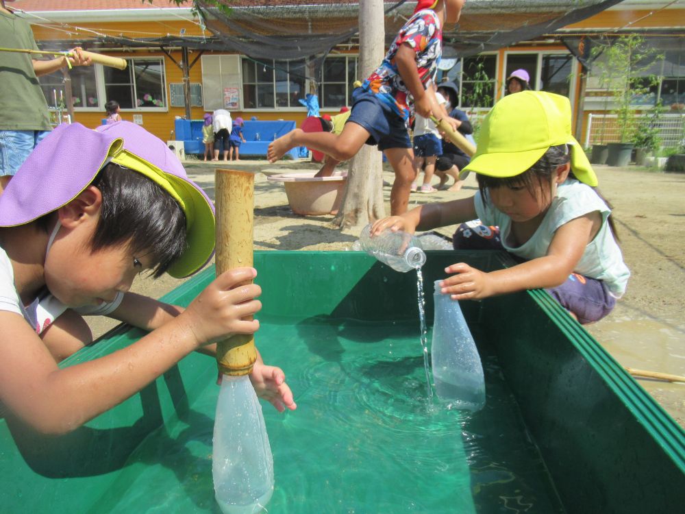 「ここでみんな水を汲んでいるみたいよ！！私もやりたい」とHちゃん

どうやってこの中に水を入れるんだろう・・・

考えながら、ゾウ組さんのやっている姿を見ながら試行錯誤です