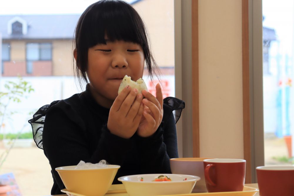 完成した【さつまいもおにぎり】は、そのまま給食でいただきます♡
やっぱりみんな、まずはおにぎりに手が伸びます♪
「まだあったかいね～」「おいしそ～」と友達と話しながら、大きい口でパクッ！
自分で作ったおにぎりを満足そうに食べる様子に、見ている方も心が和みます。

ご家庭でも簡単に作れる「おにぎり」。好きな具を入れて、ぜひ作ってみて下さい♡