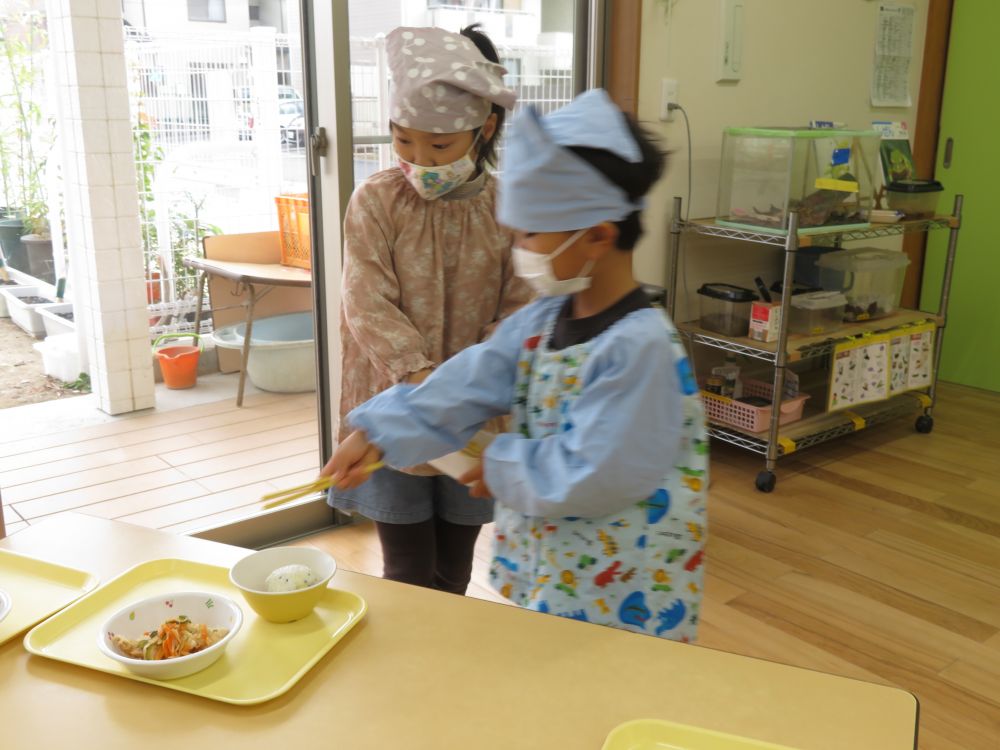 お皿を運ぶときにも、
｢ご飯が左で・・・｣と、置く位置にも気を配ります。
わからなくなった時は、友達と相談しながら・・・。
お皿の場所や箸の向きなど、また汁がこぼれないようになど、配膳一つでも気をつけることがたくさんあるね。
友達が食べやすいように、丁寧に落ち着いて・・・
新しく始まった給食当番、応援してるよ♡