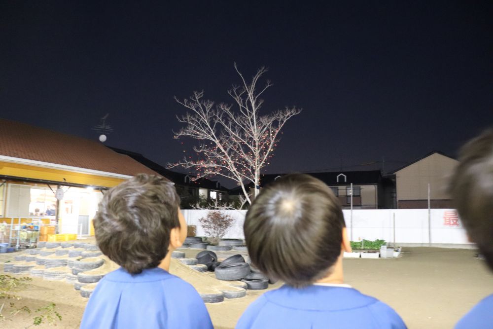 陽が落ちる時間も早くなり
夜が長いのも冬の季節の特徴

そんな長夜に輝くイルミネーション

昼間に設置している時は、なんだか線を木に巻いているだけで
イメージがつきにくかったけど
暗くなりライトアップをすると子ども達は大喜び