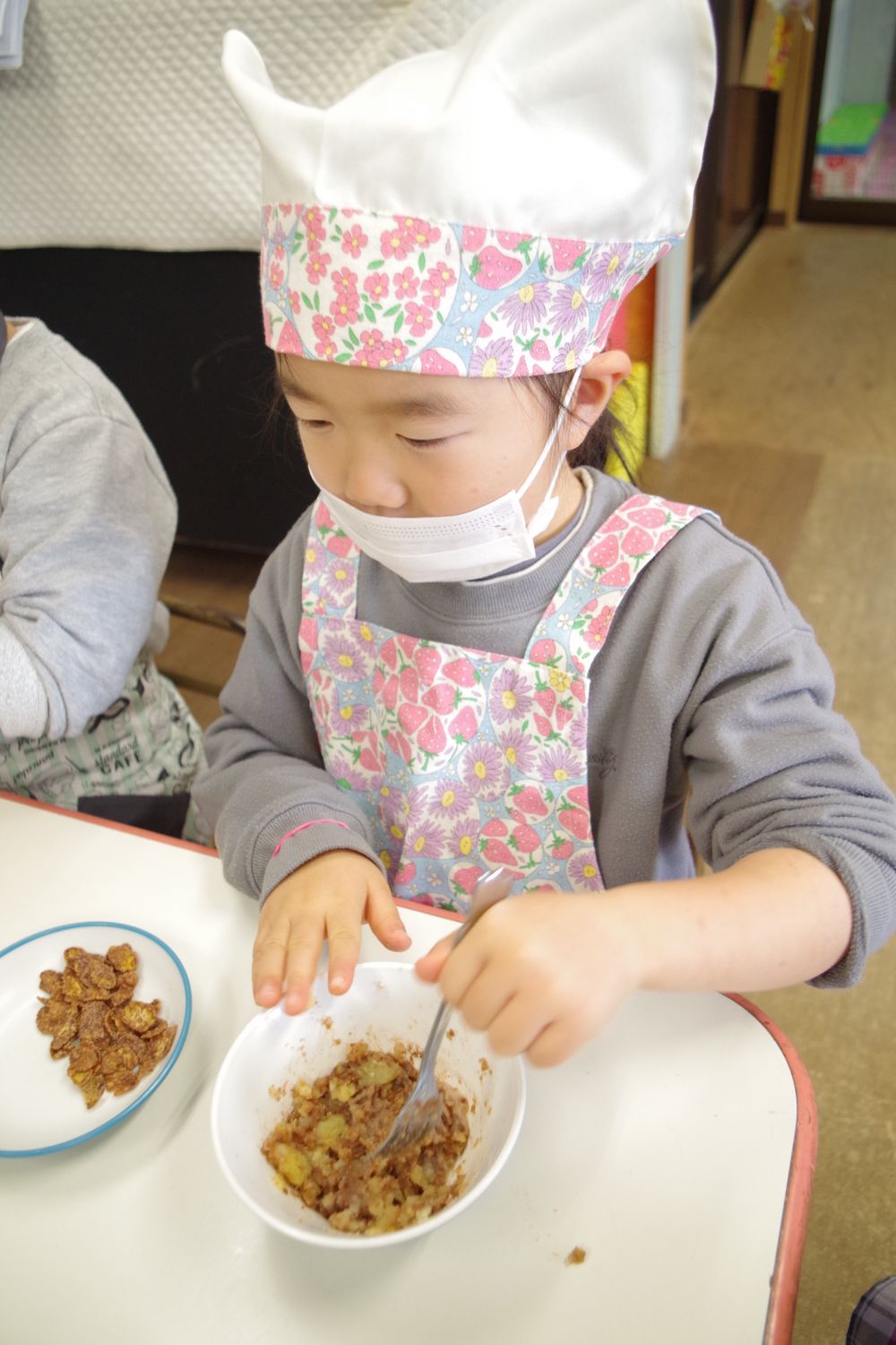 作り方の説明をしていると・・・今日はいつも以上にしっかりみんな聞いていました！
早く作りたい気持ちが伝わってきますね♡

器に入っているさつまいもをフォークで潰します。

｢次は何するん？｣
｢これとこれを混ぜるんよ！｣

友達同士で教えてあげながら進めていきます☆