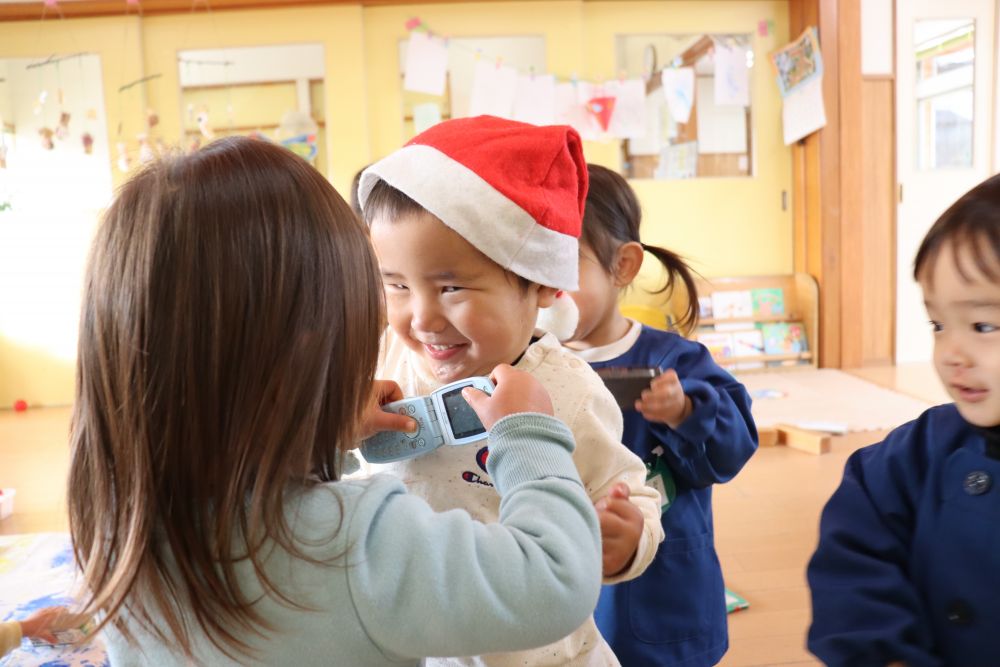 1歳児ヒヨコ組の部屋では

サンタの帽子をかぶるＩ君
それを追いかけカメラ付き携帯電話で写真を撮るＵちゃん
「ハイチーズ」

子ども達のやり取りを見ながらみんな笑顔に♡