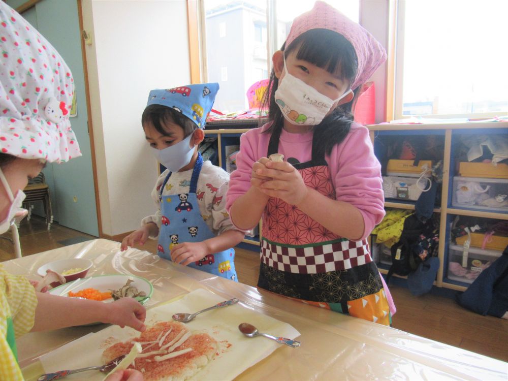 ケチャップをご飯に塗りながら聞こえてくる会話・・・。
「いい匂いしてきたねー。もう食べたいね。」
「まだ早いじゃろ～」
「あ、ここまだ白いよ。ここにもケチャップ塗ろー」
「ぼくもうケチャップないけど、そっちある？」
食べるのを楽しみにしている様子や、友達と相談しながら作っている姿がとても微笑ましかったです♡

つぎは野菜を彩りよくのせていく作業♪
エリンギやまいたけ、水菜は切っていないので、自分たちで食べやすい大きさにしてからトッピング☆
「エリンギかたいねぇ。なかなかさけんよ～」
「茶色いとこからしたら簡単だったよ」
と、ここでも友達同士、協力し合っています。