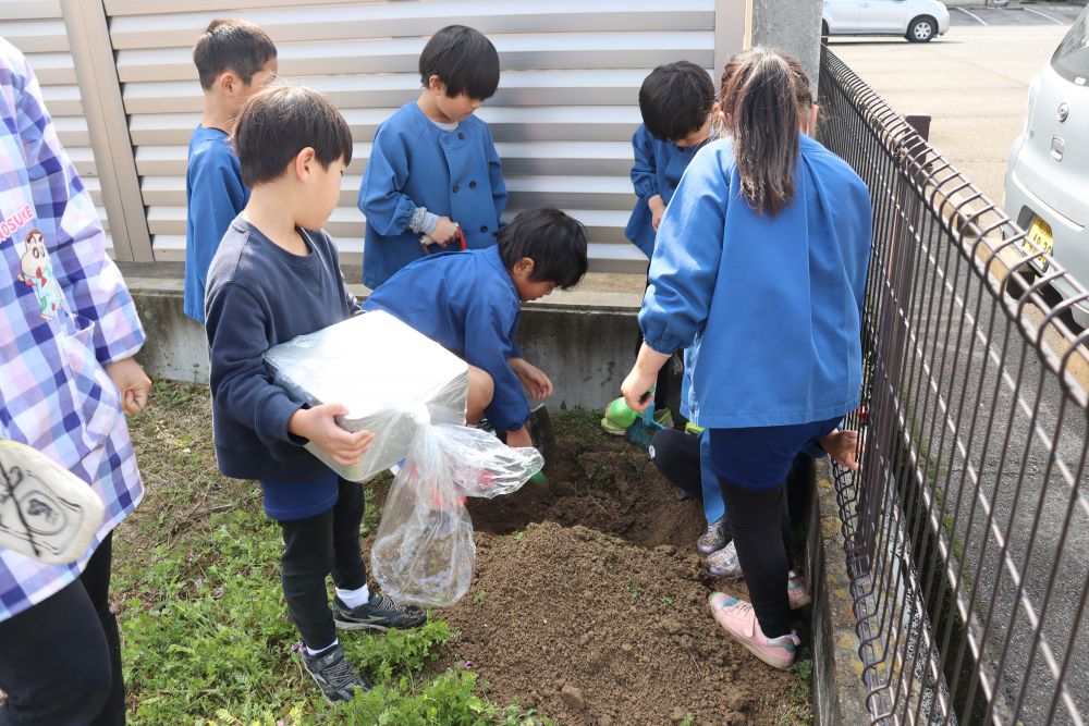 ではでは、職員駐車場の隅っこをみんなで掘削


一生懸命に穴を掘る子ども・・・

一生懸命に雑草摘みをする子ども・・・

