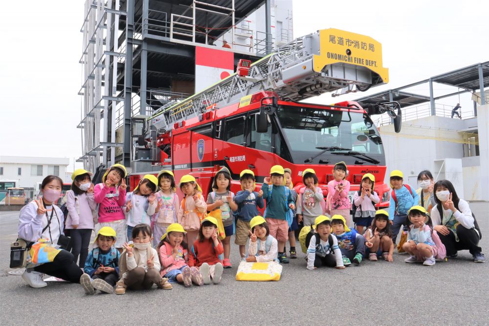 大きなはしご車の前で記念の一枚☆

　「このはしごはビルの１４階までのびるんだよ～」と消防士さん
　「お家より大きいじゃん！」とみんなびっくり！

