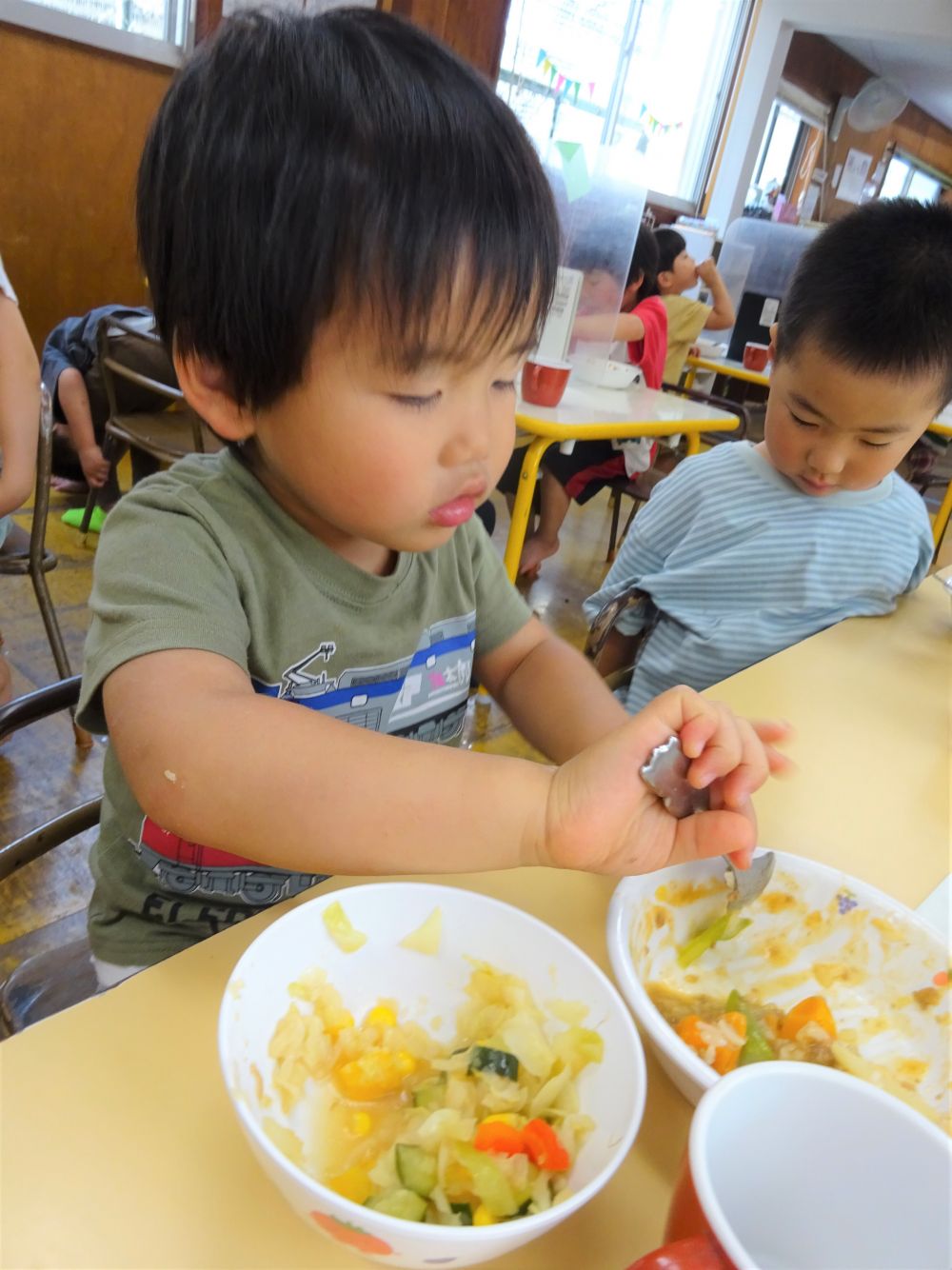 今日はリス組さんを覗いてみました。

門田認定こども園に来て２ヶ月が経ち、最初の頃に比べると
ずいぶん給食時間も落ち着いてきたように感じます♡

今日のサラダは【マセドアンサラダ】、野菜がたっぷり入って玉ねぎドレッシングで味付けします。・・・子ども達は少し手こずっていました（笑）だけど好きな子もたくさんいて元気いっぱい食べる様子が見られました。
【アスパラカレー】は・・・
｢アスパラってどんな味がするん？｣
と、カレーを心配そうにスプーンですくい口に入れるまでちょっと時間がかかりましたがパクリと一口食べると
｢うーん・・・｣
｢味がわからん・・・｣と言いながら完食していました。