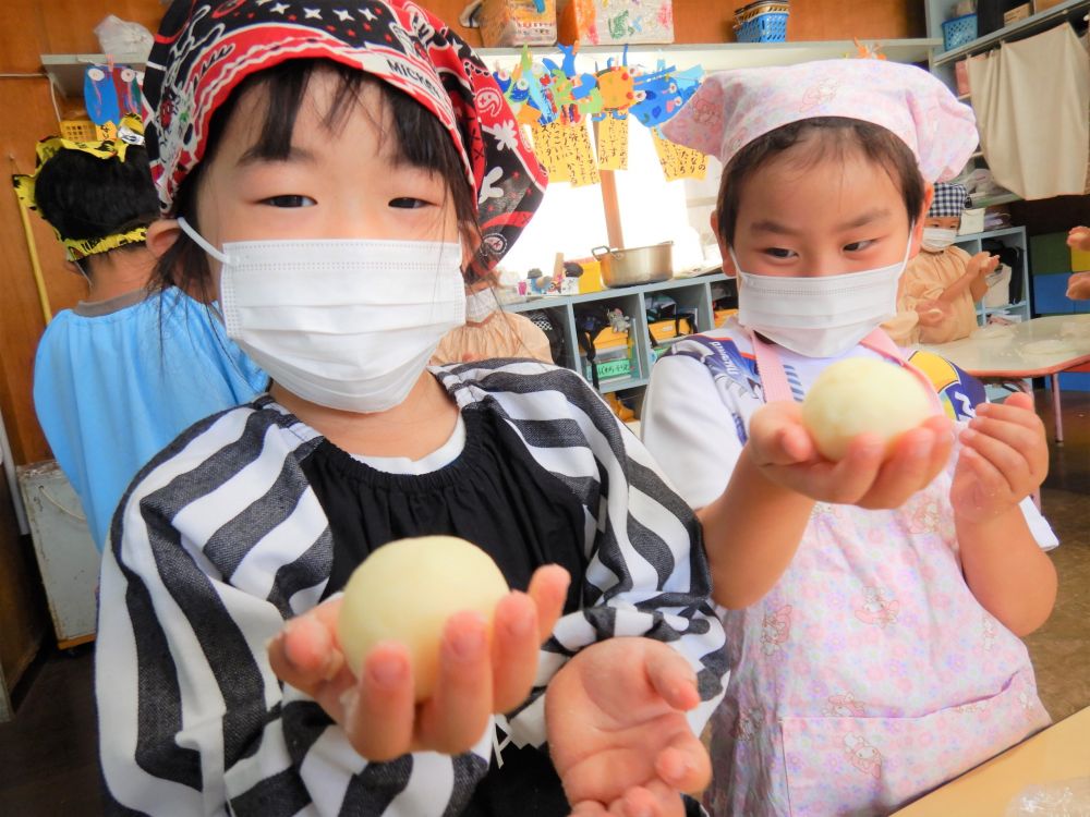 いももちの材料は

・じゃがいも
・上新粉
・塩

の3つです。
袋の中に茹でたじゃがいもを入れてしっかりモミモミ。
じゃがいもが潰れたら上新粉と塩を入れてモミモミ・・・。
お団子状になったら手のひらで少し潰して出来上がり。

あとは給食室で焼き上げて、バターしょうゆを塗って完成です！！