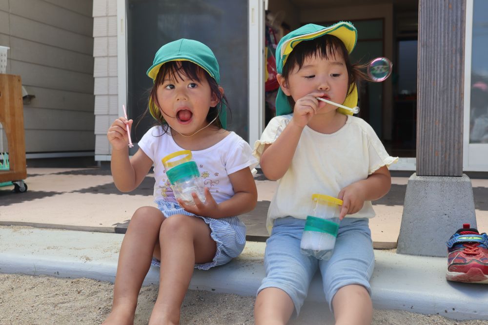 こちらは、シャボン玉チーム

テラスの端っこに座って・・・
「ふ～」とゆっくりな時間が流れています

「あっ！シャボン玉出来とるよ～」と、
教えてあげているSちゃん♡

シャボン玉は、口につけるものなので、
自分のマークをストローにつけて間違わないように・・・
コロナ対策もしながら・・・