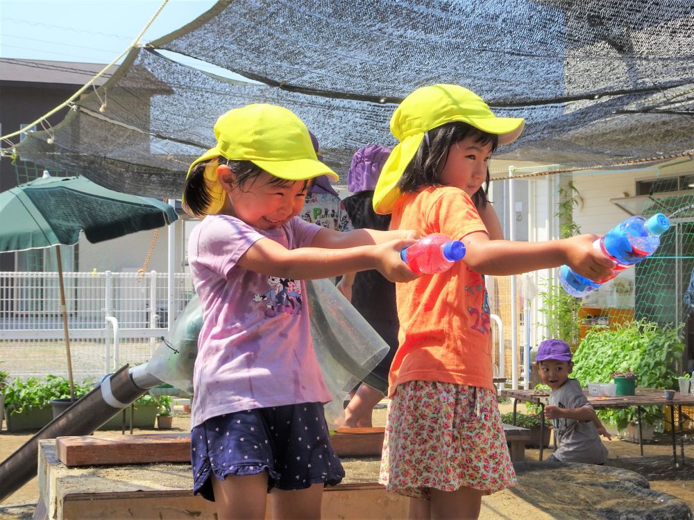 水鉄砲を握りしめ、ワクワクしながら園庭へ！

「きゃー！冷たーい！」
「仲間になってから、一緒にかけようー！」

シャワーのように水をかけてみたり、
友達とかけあいっこをしたり・・・

自分たちで遊びを見つけて、全力で楽しんでいます♪
