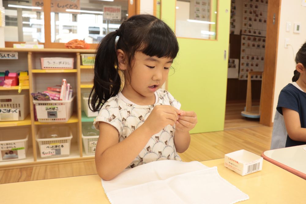 まずは玉ねぎ染めの下準備
ハンカチに自分の名前を安全ピンでつけてビー玉を輪ゴムでしばりつけていきます

上手にできるかな？