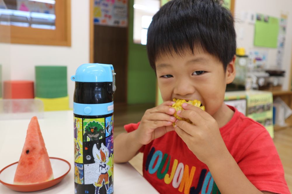 おやつの時間、自分たちが剥いたとうもろこしの登場に嬉しそうな子ども達！
「これ、ボクたちがむいたやつよね？」
「いいにお～い♡」
と、早く食べたそう♪

「いただきます」をして、まずはとうもろこしを頬張る子ども達。
「あま～い」と歓声が上がります☆
中には、歯の生え替わりで前歯がぐらぐらしていて
「前の歯でかめれ～ん」と言っている子も何人かいましたが、他の歯を使いながら上手に完食！！

おいしい【夏】を味わいました♡