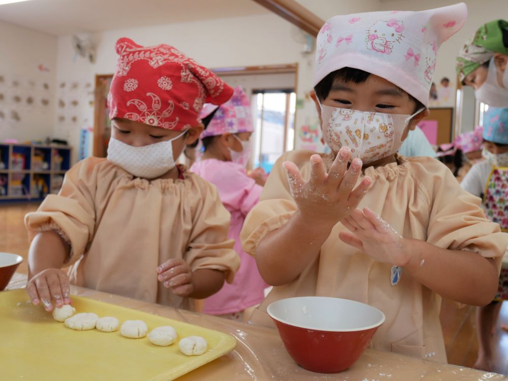 白玉粉と豆腐がキレイに混ざるまでが難しく・・・
「ボロボロのままなんじゃけど～」
「ひとつにならんねぇ」と四苦八苦・・・。
でも友達がひとり、ふたり、と丸い生地になっていくのを見るにつれ、
「粘土みたいじゃね。そうやればいいのか！」
「おっきいお団子できたかも♡」と諦めずに頑張る姿が見られました♪

生地ができたらあとは一口サイズに丸めるだけ。
「ひとり、4個のお団子作れるかな？」と言うと
「できるよ！　1・・2・・3・・4・・ほら4個！」
と上手に数える子ども達。5個や6個になる子もいましたが、そこはご愛敬♡
“楽しんで作った！！“　それが一番です♪

手についた生地が時間と共に乾いてパリパリに・・・
その感覚が不思議で楽しそう♪

初めてのクッキング、いろんなワクワク・ドキドキを体験できて、あっというまの時間だったね。