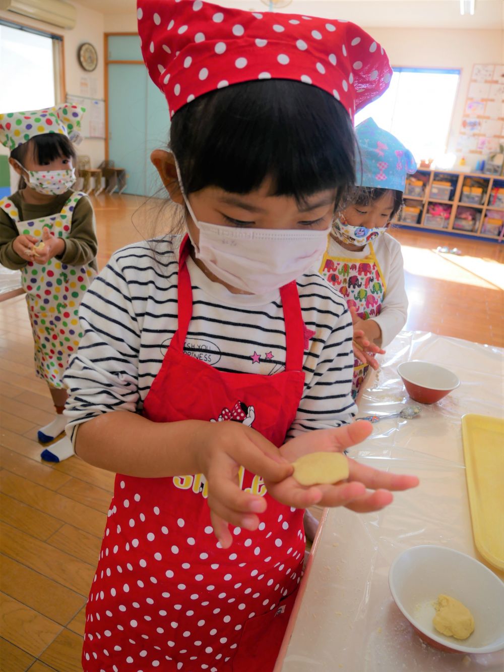 生のレモン果汁をおそるおそるぺろっ！
子ども達の目が大きく見開かれたり・・・ビックリしすぎて目をつむったり・・・
それぞれの反応が素直で可愛らしかったです♡
中には「おいしい！」と言って、もぐもぐ食べ、皮だけになっている子もいましたよ♪

いよいよ、生地作り。
材料を順番にお椀に入れていき、その都度よく混ぜます。
「指についてとれんよ～」
「さらこなが、だんごになってきたかも！」
と、さらさらの粉が段々とひとまとまりになる感触と、変化していく様子を楽しみました♪