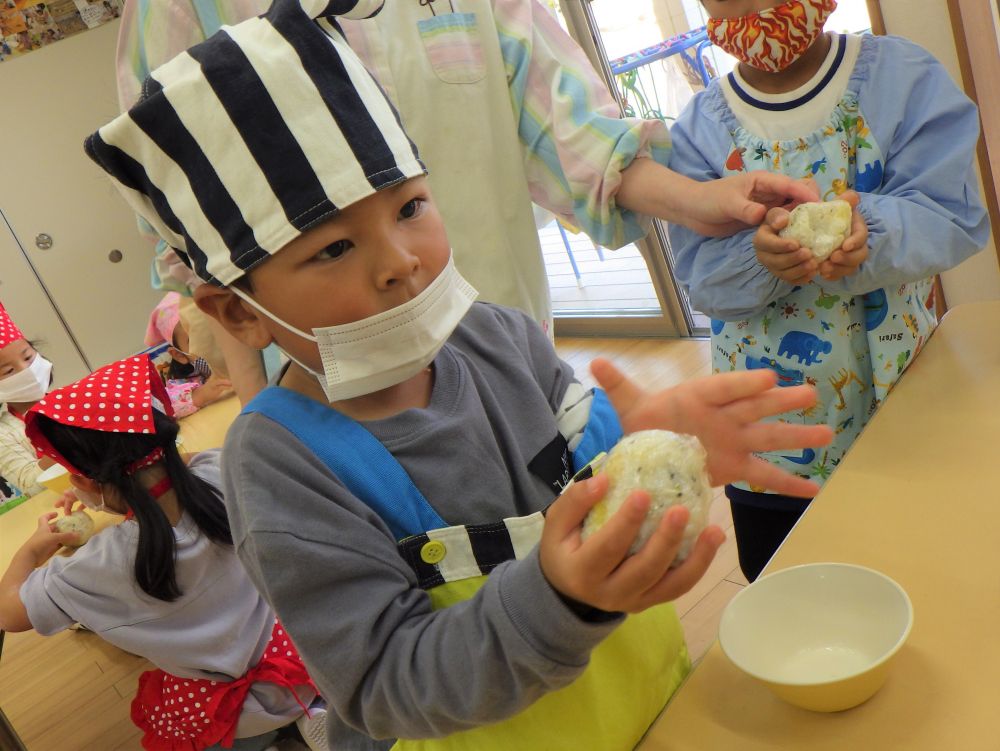 家とは違う、大きな炊飯器で炊いた、さつまいもご飯。

出来たてのアツアツを、さっそく握ります♡
一人分のご飯を、上手にラップにくるみ、にこにこ顔で「ぎゅっ」と持ったＲくん。
「あっつ！！」
思ったよりご飯が温かかったようで、目を丸くしてビックリ顔。
「こんなにあついのか～」
と言いながら、左右の手で交互に持ったりはなしたり・・・
ほどよく冷めたら、改めて両手で「ぎゅっ♡」