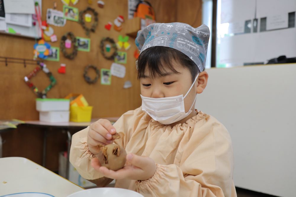 あんにコーンフレークをさしていきます♡
「松ぼっくりみたいになってきたー！」
「俺のは顔の形にみえる☆」
友達と見せ合いながら楽しそうに作っていましたよ♬

最後に雪に見立てた砂糖をかければ完成です♡
