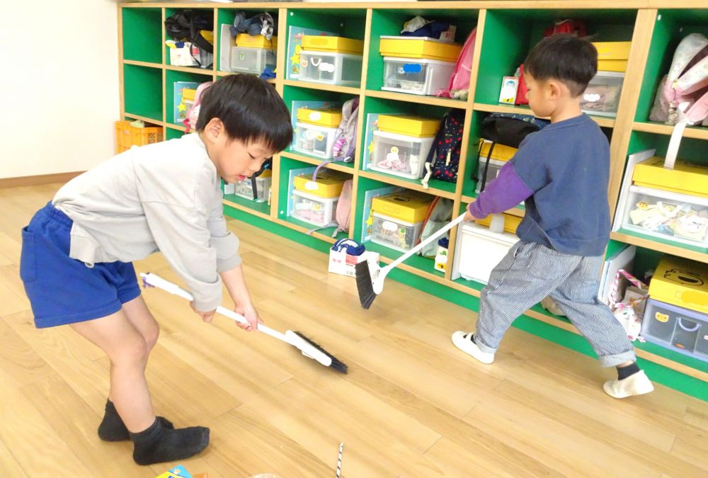 　「見て！ここにゴミが集まってる」
　「こっちにもあったよ！きれいにしないと！」
部屋の隅や机の下など、目を凝らしながら友達と一緒にゴミを探して掃き掃除
ほうきやちりとりを交代して使いながら、１か所にゴミを集めて捨てる姿も！

掃除も終わり、部屋を見渡しながら休憩していると・・・
　「お掃除って疲れるね」
　「でも、きれいになったら嬉しいね♡」
　「次のゾウ組さんのためにピカピカにできたね！」
達成感を感じながら話していたゾウ組さん
キリン組さんへの期待がより膨らんでいました♡