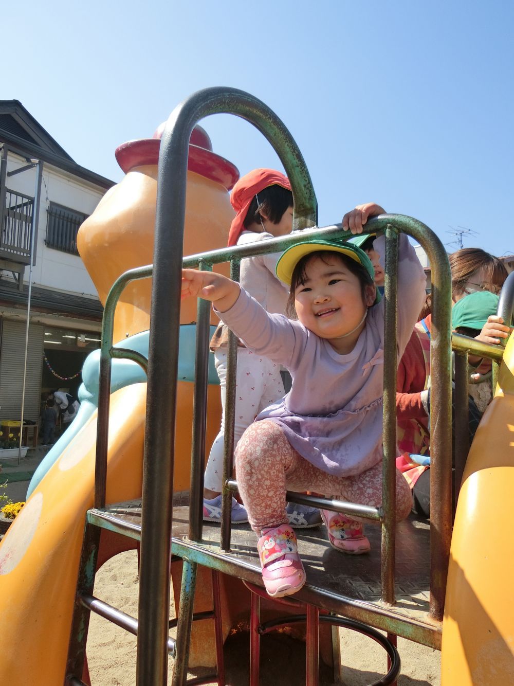 年上児の姿を見て、早速チャレンジするAちゃん！
慎重に手を伸ばし・・・やっぱりやめようかな・・？
登り棒の下では、お友達が応援「Aちゃんばんばれ！！」