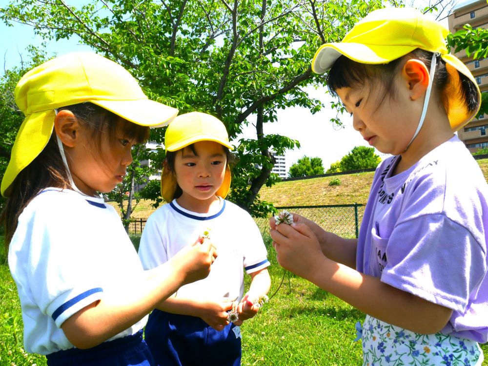 自然の中での遊びは無限大…♡
やってみたい！面白い！楽しそう！
それぞれが興味関心を持ち遊びに取り入れています



友達が冠を作っている姿を見て
やってみたい！！と興味を持った友達に
「私が教えてあげる！！順番ね♪」
「まずは２つ持ってばってんにして…」
一人一人に教えてあげるＣちゃん