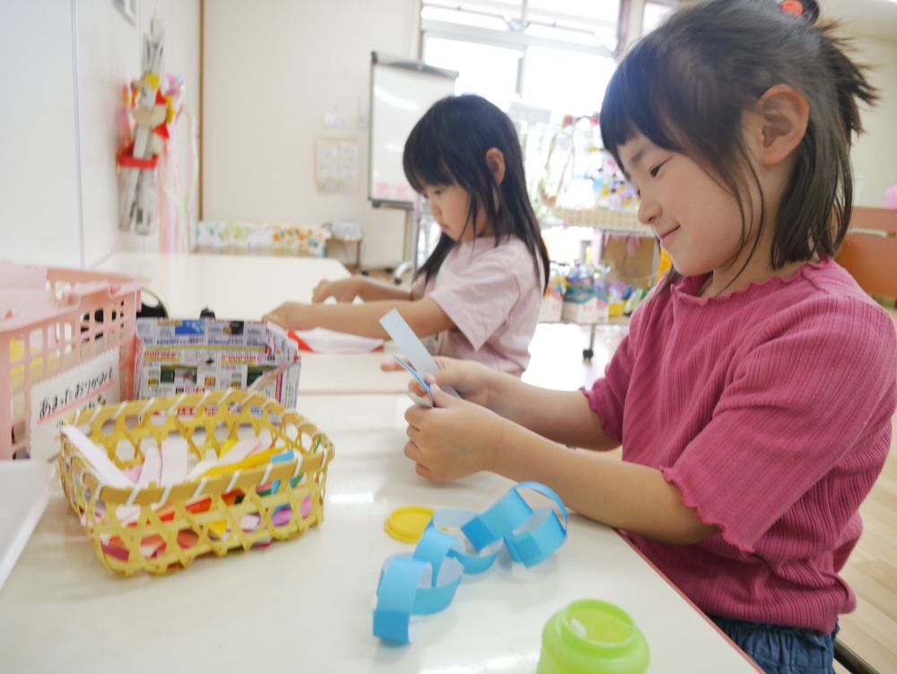 輪飾りを作ったり、お願い事を書いたり…
友達同士で教え合いながら七夕に興味を持っています
その中で、夏ならではの飾り作りや
様々な形に切ったり、組み合わせたり…
「1・2・3…」
作った輪飾りが何個あるか数えて
数や形にも関心を持っています♪