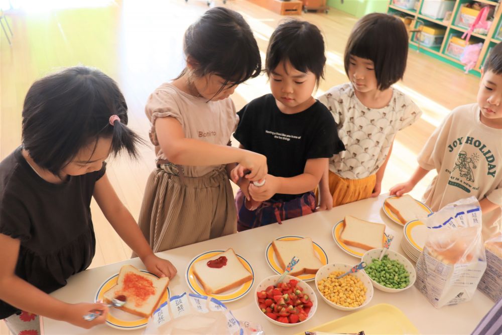 朝ごはんは園庭で栽培した野菜を使った夏野菜ピザ
トマト、トウモロコシ、枝豆
どのくらい乗せるかは自分次第
順番にケチャップをヌリヌリ♡