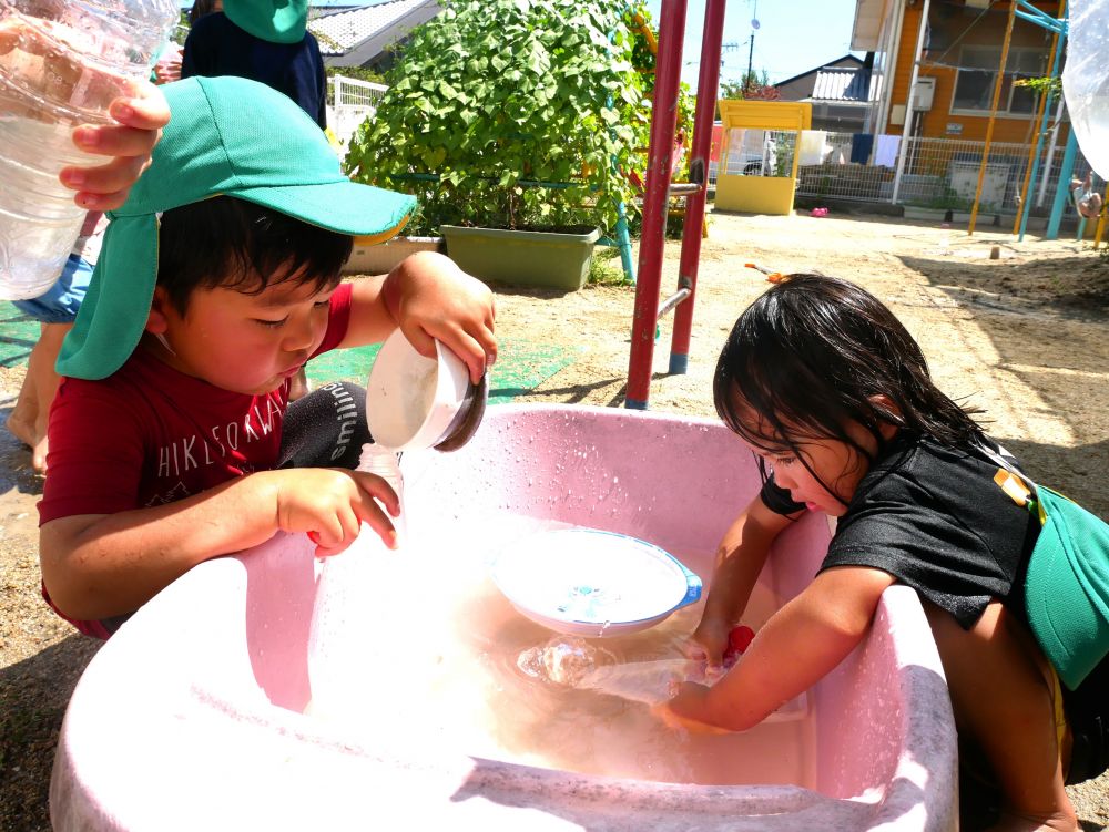 こっちでは水鉄砲に上手く水が入らない・・・
思い悩む姿も・・・
『あっ！お皿で入れてみたらどう？』
『さっきよりも水が多く入ったじゃん！』
友達と声を掛け合いながら遊ぶ姿がみられました♡