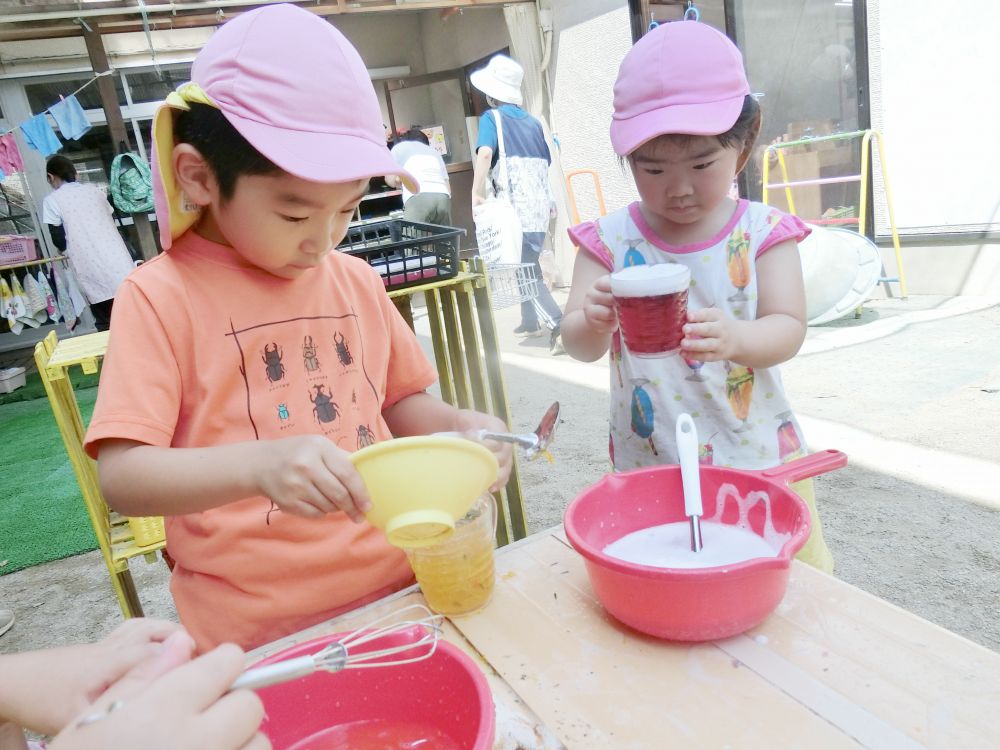 
マリーゴールドを使って
色水を作るHくん
水の量によって変わる濃いさ・・・
Hくん好みで微調整しています

お隣では泡をトッピングしている
Ｋちゃん
とってもおいしそうなジュースの
出来上がりです♡
