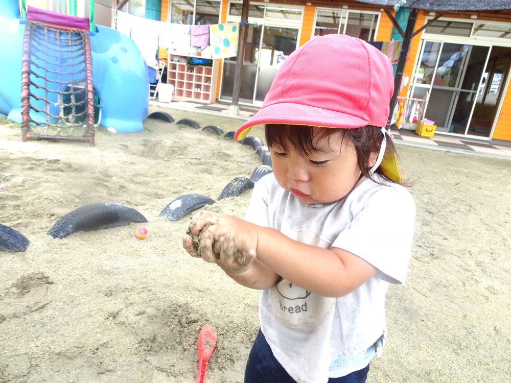 水遊びのあとは、どろんこができて・・・
同じどろんこ遊びを毎日楽しむなかでも、
すくうのを楽しむだけでなく、手で握ってギュっとしたり、
食べものに見立てて作ったりと、日々違う発見が☆



Nくんが、手でかためてみようと挑戦
手のひらに思い切りどろんこをかき集めて、
「ギュッ」と声に出しながら思いっきり固めてみる・・・

「あ！」と嬉しそうにどろんこの形の変化を見つめていました！