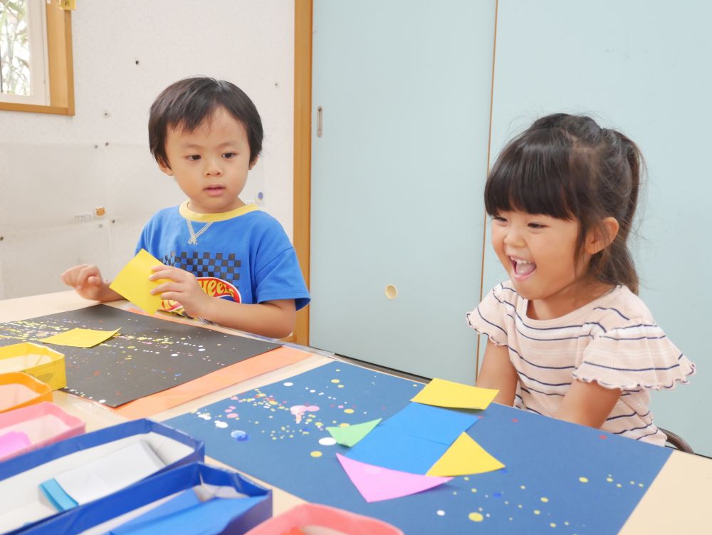 いろいろな形の折り紙を組み合わせて・・・
ロケットに見立てるAちゃん♡
『Aちゃんのロケット大きいかな？』
『画用紙からはみ出てるよ』
それも個性で面白い♡