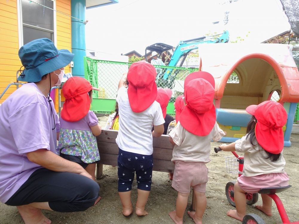 園庭のフェンス工事にはたくさんのはたらく車が！
乗り物が大好きなみんなの目がキラキラと輝きます☆



ウイーン　ガッシャーン
工事の音が聞こえる園庭へ！
目の前でショベルカーが動く様子をじーっと観察・・・