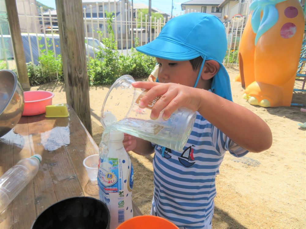 カルピスいっぱいになるかな～

色が付いた水をボトルに注いでジュース作り。
穴が小さくてなかなか上手くはいらないねぇ・・・

こぼれても、何度も繰り返していっぱいになるまで頑張ったよ！
