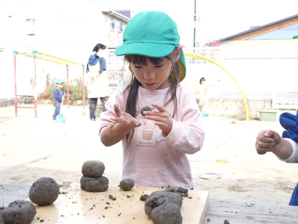 土を触り感触を楽しんだり
何かに見立てて作ることを楽しんでいます



『そーっと触らないと崩れるんだよ』
小さなお団子を大事そうに触るⅯちゃん♡