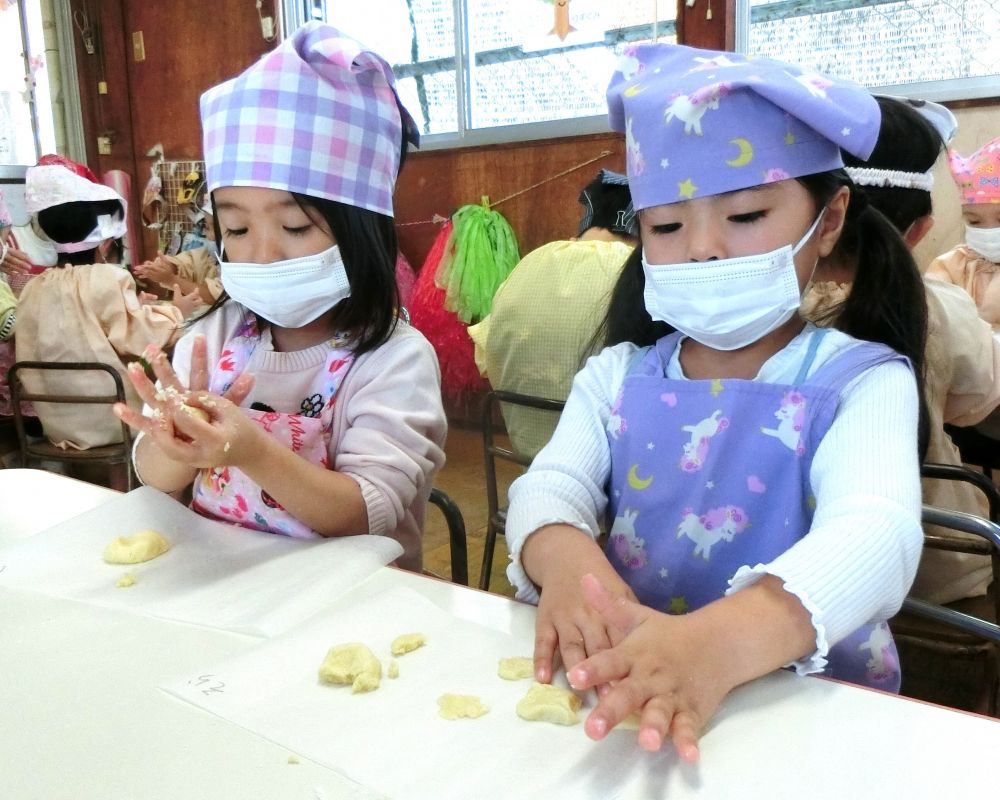 材料は
ホットケーキ粉、砂糖、レモン汁、バター
を使います。
少し牛乳で生地を柔らかくしながらみんなでひとまとまりにまとめていきます。

レモン汁を入れるとき

「そーっっと、そーっっと・・・こぼさないように・・・」
お友達も【がんばって！！】と見守りながら上手にボウルに入れることが出来ました。
