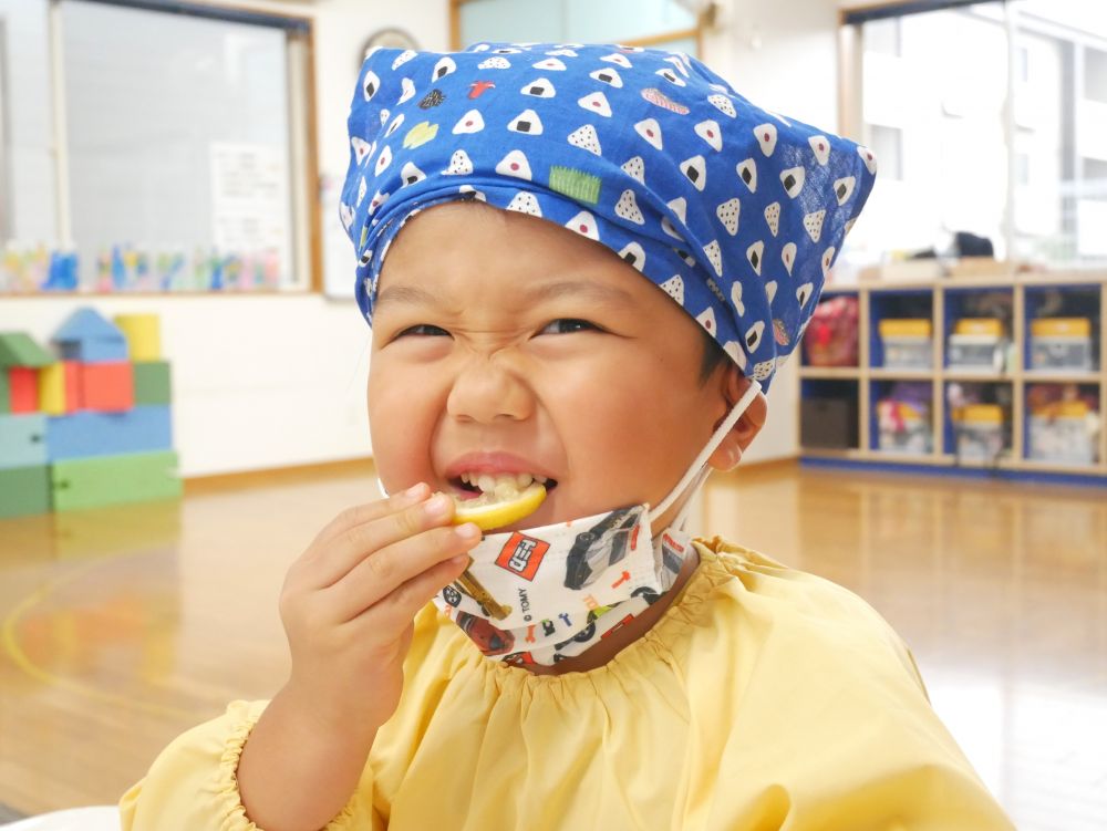 今日は、リス組さん2回目のクッキングでした。
尾道の特産品【レモン】を使って、レモンクッキー作りに挑戦です♡

クッキングの準備をし、「楽しみ～」と言いながらテーブルへ♪
クッキーを作る前に、匂いを嗅いだり、味見をしたりして、尾道レモンと親しみます。
勢いよく「ガブッ」といく子もいれば、おそるおそる「ペロッ」としている子もいました。その後の、みんなの反応は？？
「・・・すっぱ～～～い！！」と、口をとがらせたり、目を真ん丸にしたり可愛い反応が見られました♡
意外と平気な子が多くいて、「おいしい！」「あま～い」という声も聞かれました。中には皮まで食べた子も♪