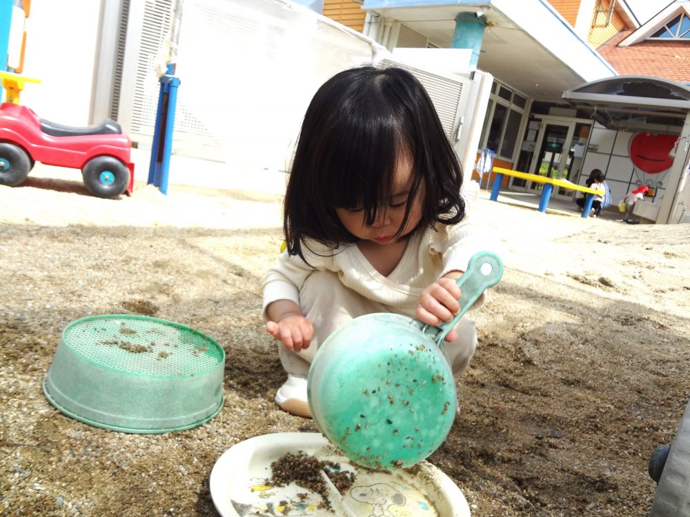 外遊びでは、自分で見つけたお鍋を使い、すくった砂を
お皿に移し替えることに集中していました。