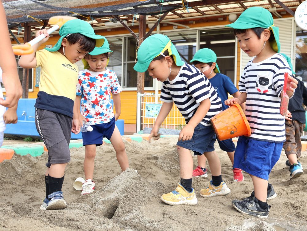 ひらめいたことを共有し
遊びがどんどん広がっていく・・・
”こうしたらいい” 自分たちで考え工夫する・・・
「山の中に水流してみようや!」
「じゃあ道を作ったらいいんじゃない?」
「トンネルを通るように道を作ろう!」
「大きいスコップより小さい方がいいよ!」