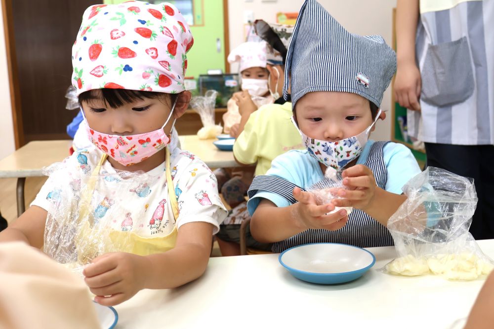 水曜日に収穫したじゃがいもを使い、ゾウ組さんがおやつ作りに挑戦です！
仲良しの友達と一緒に、自分たちが収穫したじゃがいもでクッキング♡
給食室にきて「先生、じゃがいも準備してある？」と聞いてくれる子もいて・・
楽しみにしている様子は朝から伝わってきました♪

エプロン・三角巾・マスク、と自分で準備をして、クッキングスタート☆
まずは、ゆでたじゃがいもをつぶすことから・・・
「あったか～い」
「すぐつぶれるね～、いい匂いもしてきた」
感じたことを友達同士で伝え合います。
